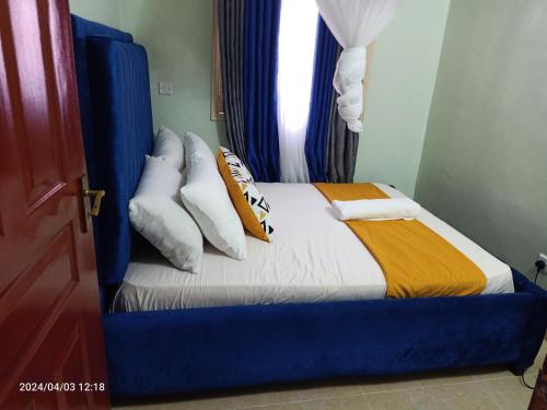 基苏木Monalissa One bedroom apartment的卧室配有带枕头的床铺和窗户。