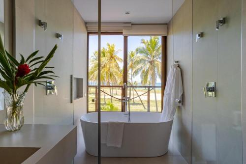 普拉亚多Luxo a 50 m da praia, acesso ao Iberostar Resort的带浴缸的浴室和大窗户