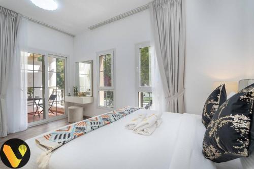 迪拜Vogue Villa Near Golf/Ski Dubai/ Ibn Battuta Mall的白色卧室设有大床和窗户