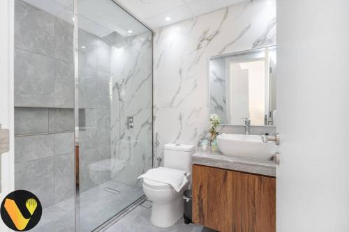迪拜Vogue Villa Near Golf/Ski Dubai/ Ibn Battuta Mall的浴室配有卫生间、盥洗盆和淋浴。