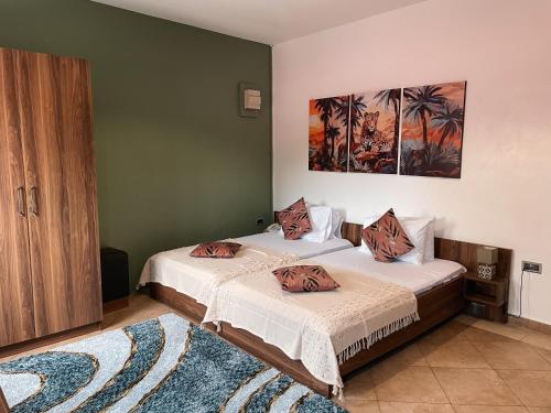 阿克拉Sky Suites Osu的绿墙客房内的两张床