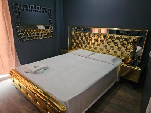 巴拿马城RESIDENCIAL LA MALVARROSA的一张带金色床头板和镜子的床