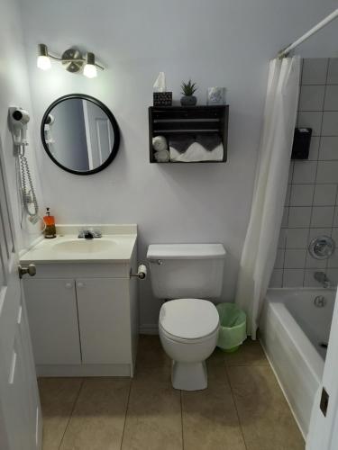 CabanoMotel Cabano-Relais的一间带卫生间、水槽和镜子的浴室