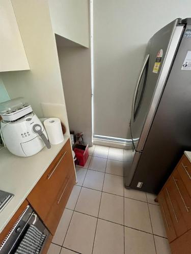 悉尼B的带冰箱的厨房和瓷砖地板。