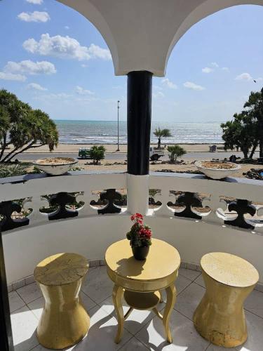 吉布提Brise de Mer Azur的一个带桌椅和海滩的阳台