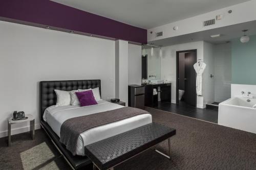 伦敦都会酒店的一间卧室设有一张大床和一个浴缸