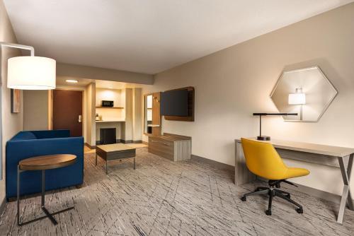 莫比尔提尔曼斯角莫拜尔西I-10智选假日酒店及套房的客厅配有蓝色的沙发和黄色的椅子