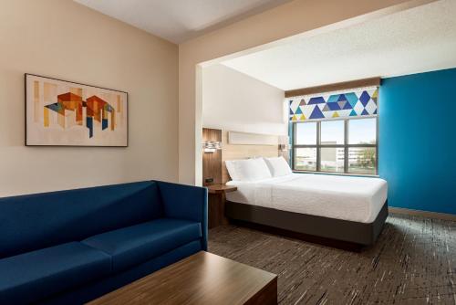 莫比尔提尔曼斯角莫拜尔西I-10智选假日酒店及套房的酒店客房,配有床和沙发