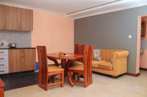 MeruTamwe ltd Airbnb &studios的厨房配有桌子、椅子和沙发