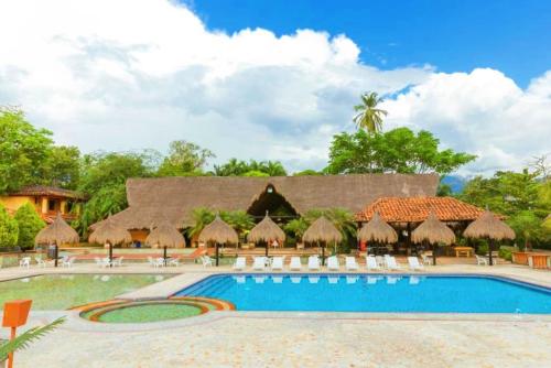 圣菲德安蒂奥基亚博通德索酒店的一个带椅子和遮阳伞的游泳池的度假酒店
