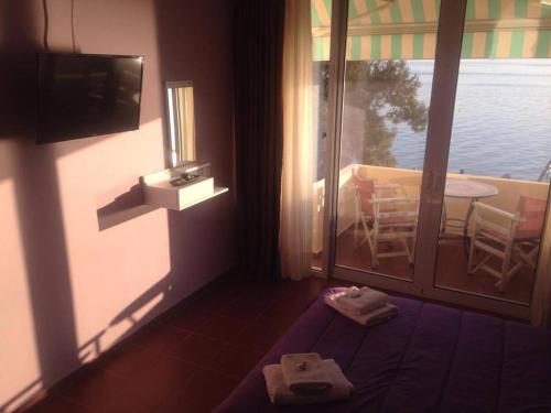 卢特拉艾季普苏Maravellia的客房设有一张床和一个带桌子的阳台