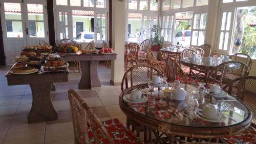 伊列乌斯Pousada Arco Iris Ilhéus的一间餐厅配有桌椅,提供食物