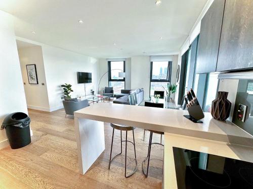 伦敦Battersea 3 Bedroom penthouse with private terrace的厨房以及带大型白色台面的起居室。