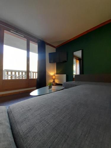 贝斯和圣阿纳斯泰斯T2 confortable - Piscine chauffée - Super Besse的一间卧室设有一张大床和一个大窗户