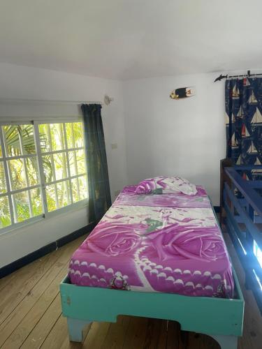 拉斯特拉纳斯Villa Del Mar的一张床上的床上,上面有紫色毯子