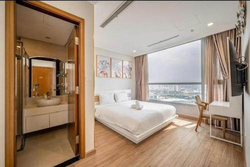 胡志明市Vinhome Landmark Suites的一间卧室配有一张床,浴室设有水槽