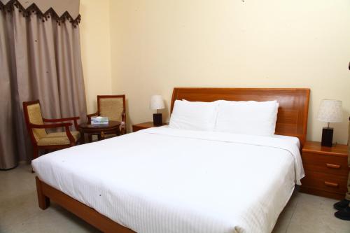 阿吉曼梦想宫殿酒店的卧室配有一张白色大床和两把椅子