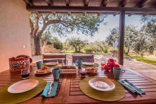 帕尔蒂尼科Villa con piscina Casale di Giò nel Golfo di Castellammare的一张木桌,上面放着食物盘