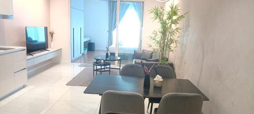 吉隆坡QUILL APARTMENT SKY 1018的客厅配有桌椅和电视。