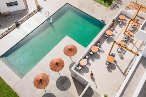 哈维亚Hotel Boutique Mi Almazara的享有带遮阳伞的游泳池的顶部景致