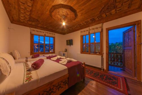 番红花城Gunes Konak Otel Safranbolu的一间卧室设有两张床和大窗户