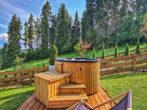拉普斯尼恩LK Resort Łapsze domy z prywatną balią i sauną的木制热水浴缸,位于木甲板上