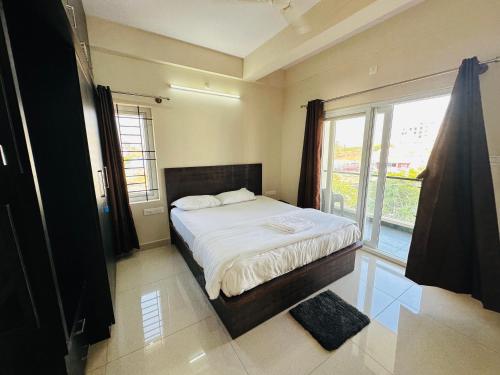 迈索尔Oryx Residences - Luxury Serviced Apartments的一间卧室设有一张床和一个大窗户