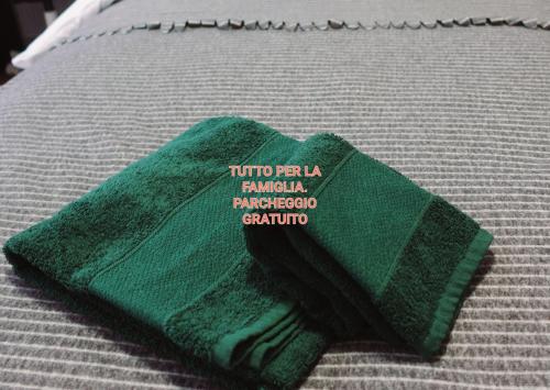 科莫SAGNINO COMO LAKE APARTMENT的床上的绿毛巾