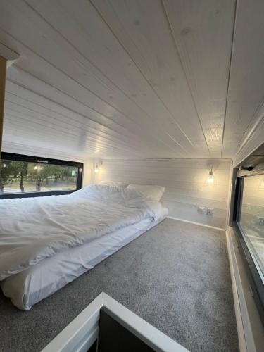 TokarniaW Sosnach的一个小房间,设有一张大白色的床,带有窗户