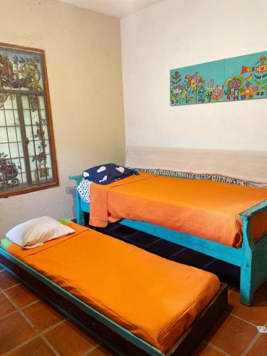 科尔多瓦Lunas de Spilimbergo的配有橙色床单的客房内的两张床