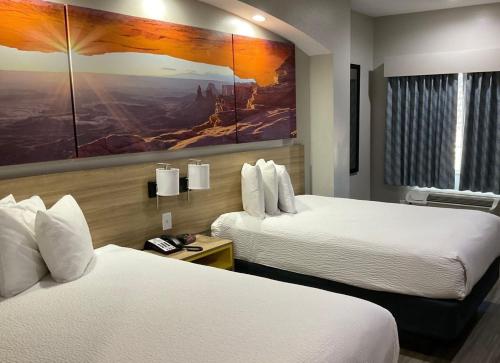 亨博尔杭博/休斯敦洲际机场戴斯酒店的酒店客房设有两张床,墙上挂有绘画作品