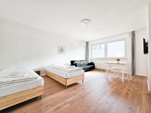 杜塞尔多夫RAJ Living - 2 or 3 Room Apartments - 15 Min zur Messe DUS & 10 Min Old Town DUS的白色的客房配有两张床和一张桌子