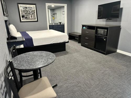 罗兰Interstate Inn的一间酒店客房,配有一张床铺、一张桌子和一台电视