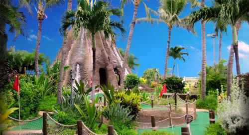 帕依亚Embark on a journey through Maui with Aloha Glamp's jeep and rooftop tent allows you to discover diverse campgrounds, unveiling the island's beauty from unique perspectives each day的一座种有棕榈树和游戏结构的花园