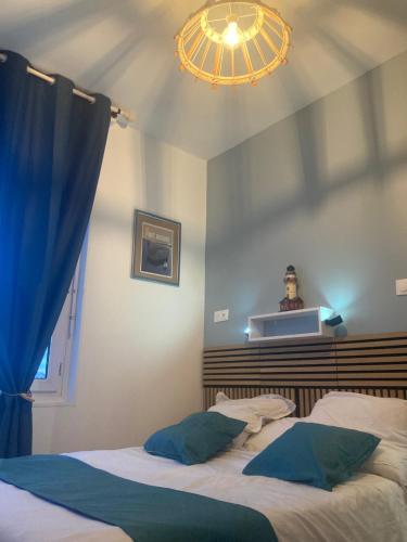 帕克斯港Les chambres du Phare的一间卧室配有两张床和吊灯。