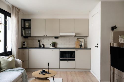 斯德哥尔摩Home Away Apartments Stockholm的一间厨房,内设白色橱柜和一张桌子