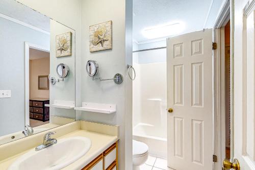 巴拿马城海滩Gulf Highlands 115 Cindy Lane的一间带水槽、卫生间和镜子的浴室
