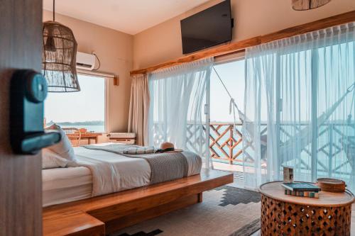 博卡斯德尔托罗Bambuda Bocas Town的一间卧室设有一张床和一个阳台的大窗户
