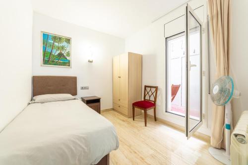 库尼特Mar & Cunit的一间卧室配有一张床和一个带风扇的窗户。