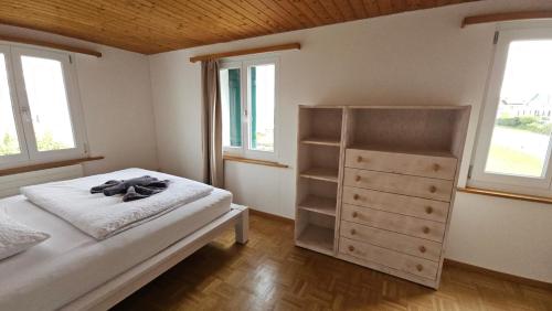 AltnauMBar Apartment的一间卧室配有一张床、一个梳妆台和两个窗户。