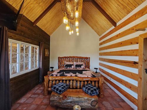 特克潘危地马拉Finca Chuchiyá cabañas Tecpan的一间带一张大床的卧室,位于一个拥有木制天花板的房间