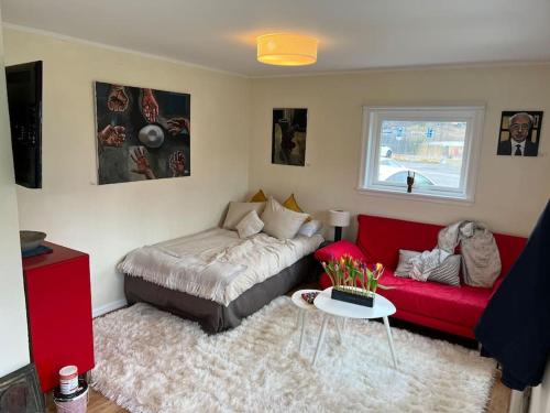 索茨霍巴根Small Seaside Cottage的客厅配有床和红色沙发