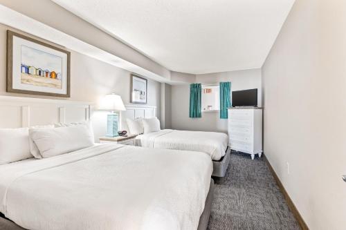 默特尔比奇Bay Watch Resort的酒店客房设有两张床和电视。