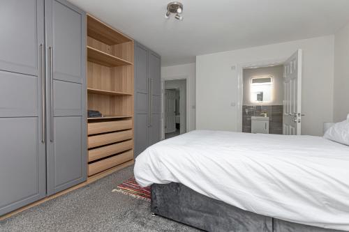 巴特利New Build 4 bed Det House in Yorkshire Nr Leeds的白色卧室设有一张大床和一个梳妆台