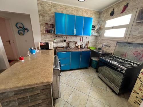 拉斯苏德尔Golden beach 2 Ras sedr Cozy chalet的厨房配有蓝色橱柜和炉灶。