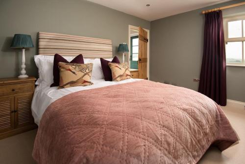 West WoodburnRisingham House的卧室配有带枕头的大型粉红色床