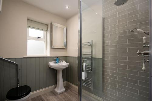 West WoodburnRisingham House的一间带水槽和淋浴的浴室