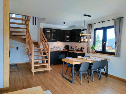 穆扎希赫尔Domki Hygge Tatra Luxury Chalet的厨房以及带木桌和椅子的用餐室。