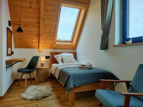 穆扎希赫尔Domki Hygge Tatra Luxury Chalet的卧室配有床、椅子和窗户。