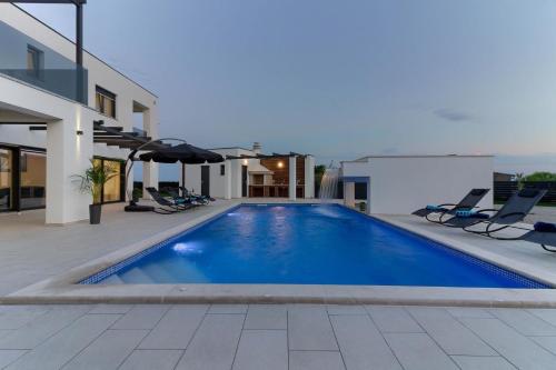 罗波里卡Ferienhaus für 14 Personen in Loborika, Istrien Südküste von Istrien的一座房子后院的游泳池